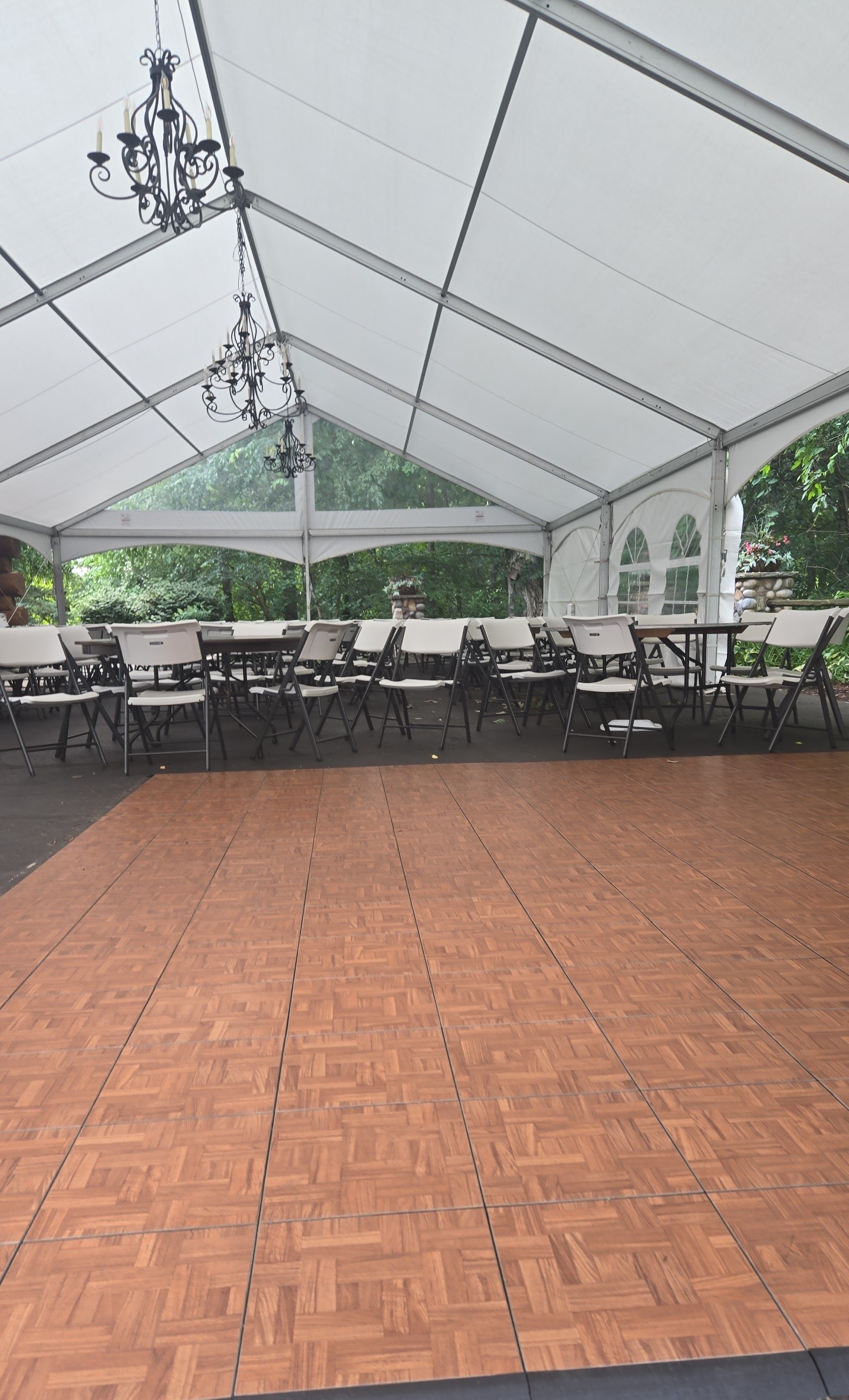 Dance floor inside clear span tent with chandelier